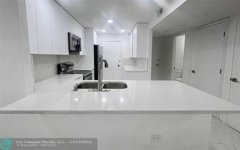 a kitchen with a sink a stove and cabinets