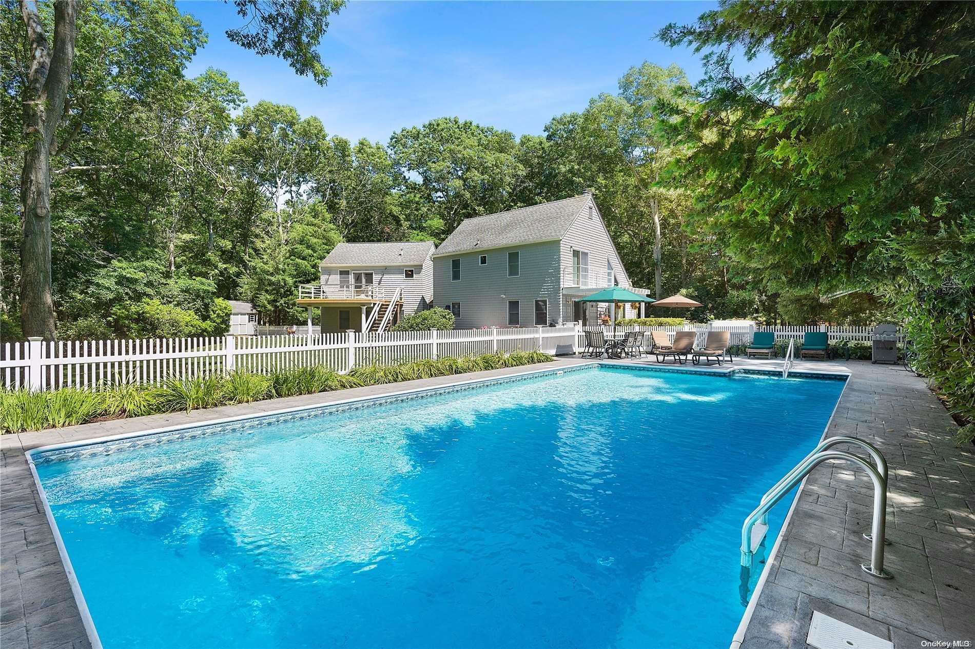 a view of a house with swimming pool and sitting area