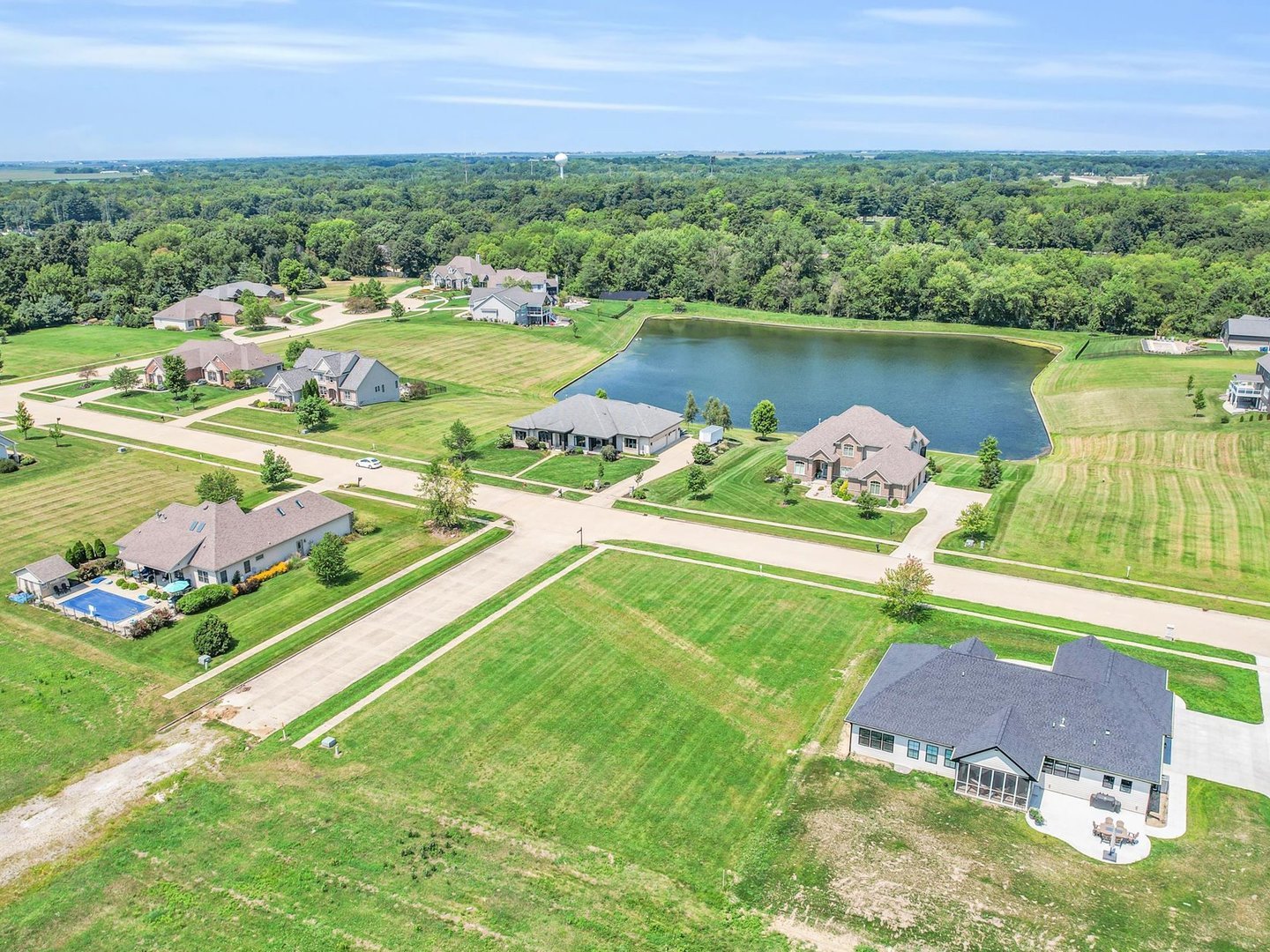 an aerial view of a house with yard lake and outdoor seating