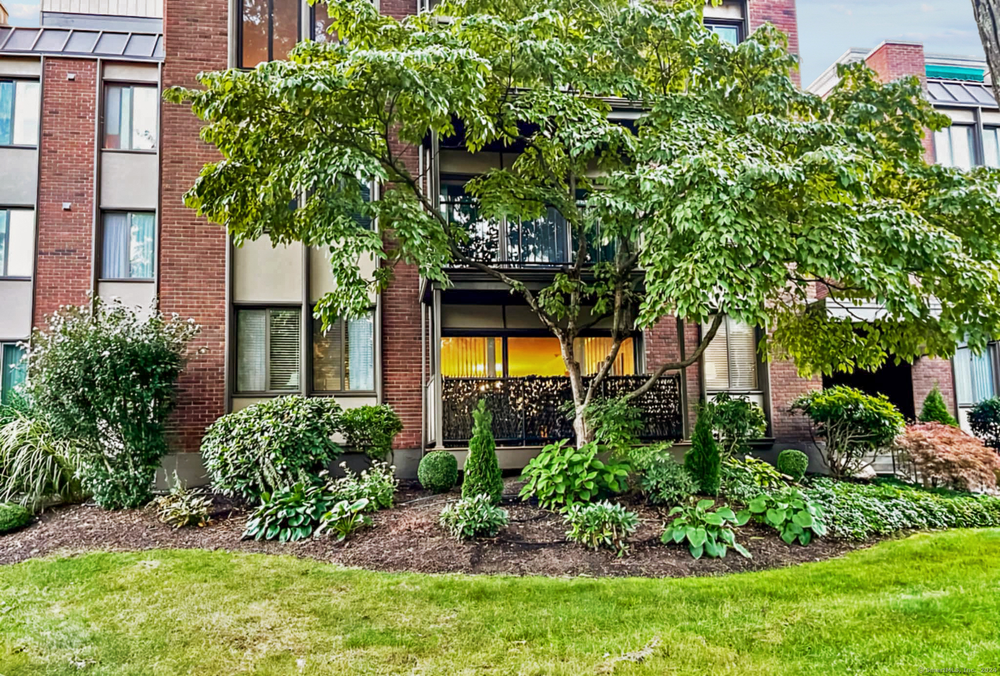 a front view of a house with a tree