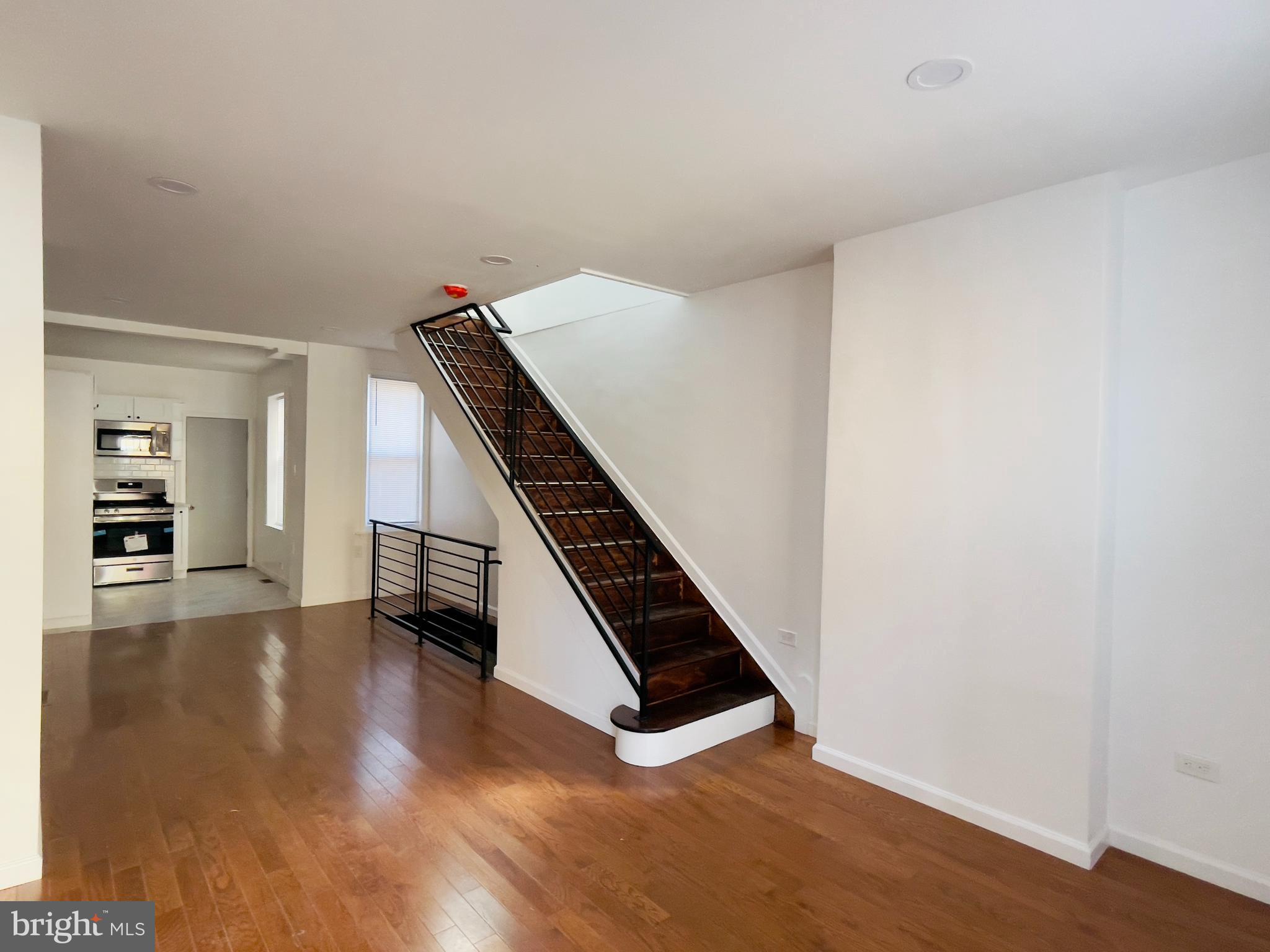 a view of an empty room with wooden floor