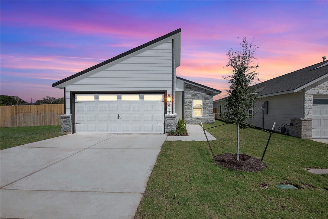 View of front facade with a yard and a garage