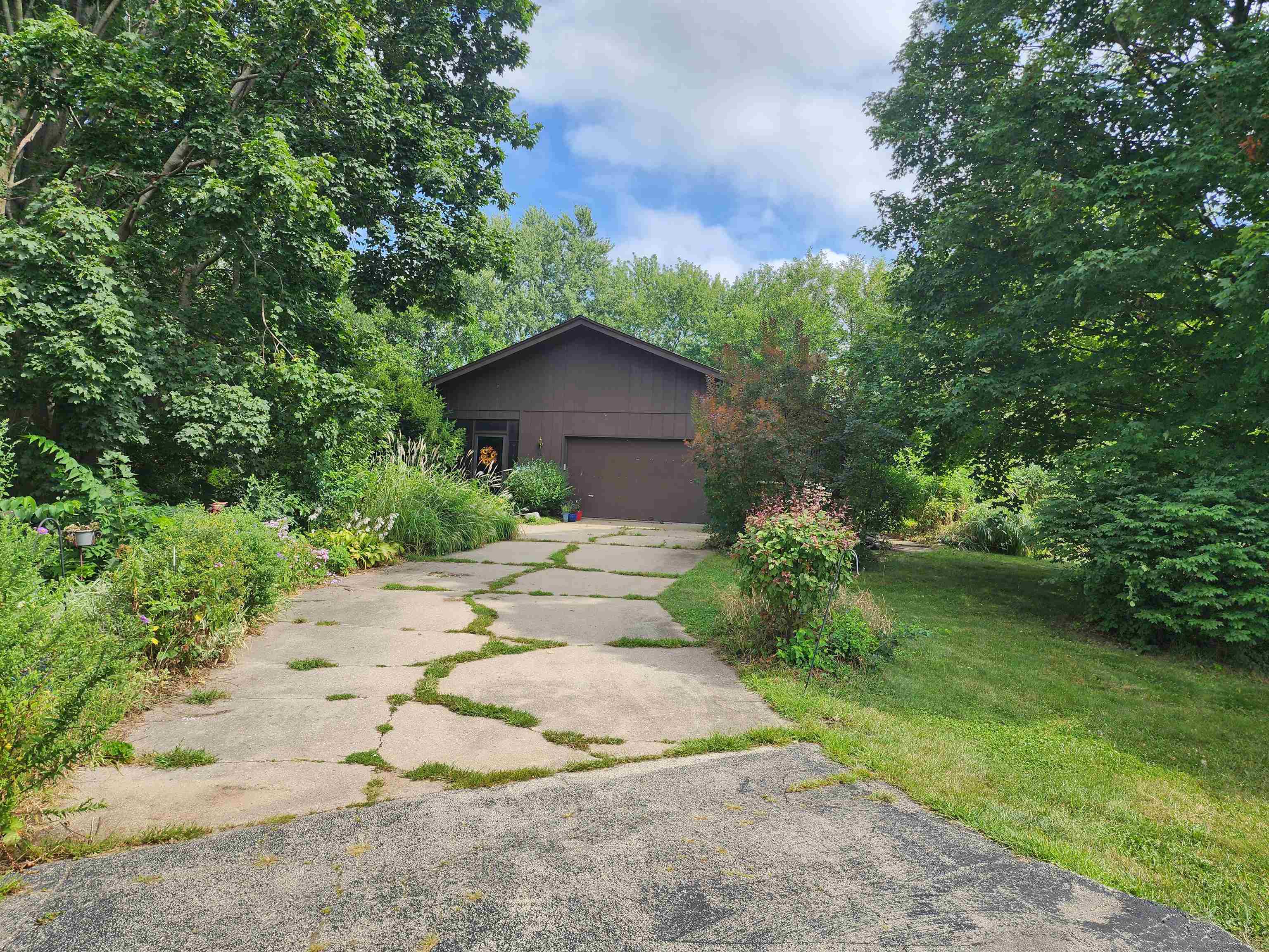 a view of a house with a yard and large trees