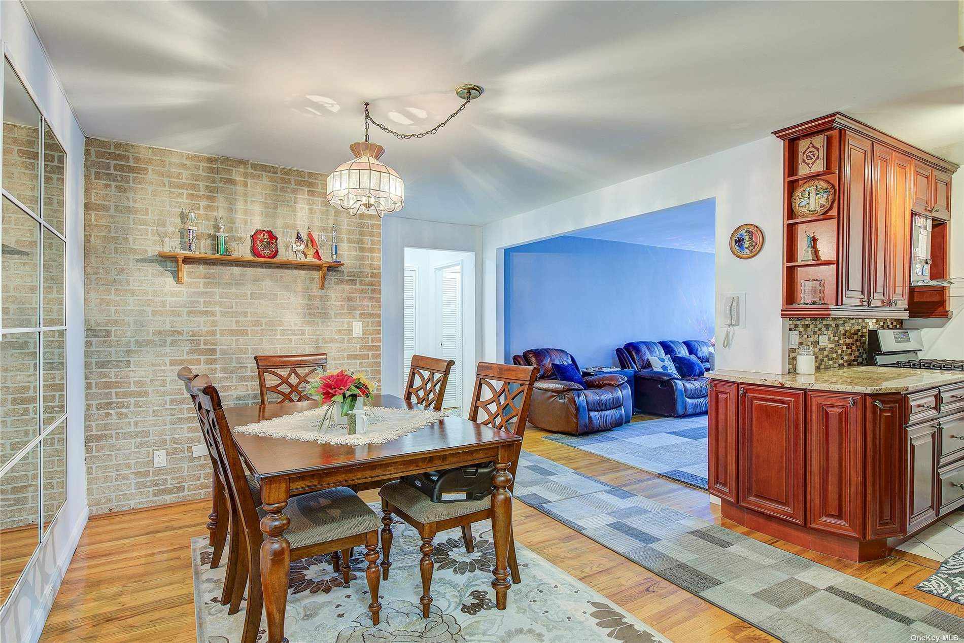 a dining room with furniture a chandelier and wooden floor