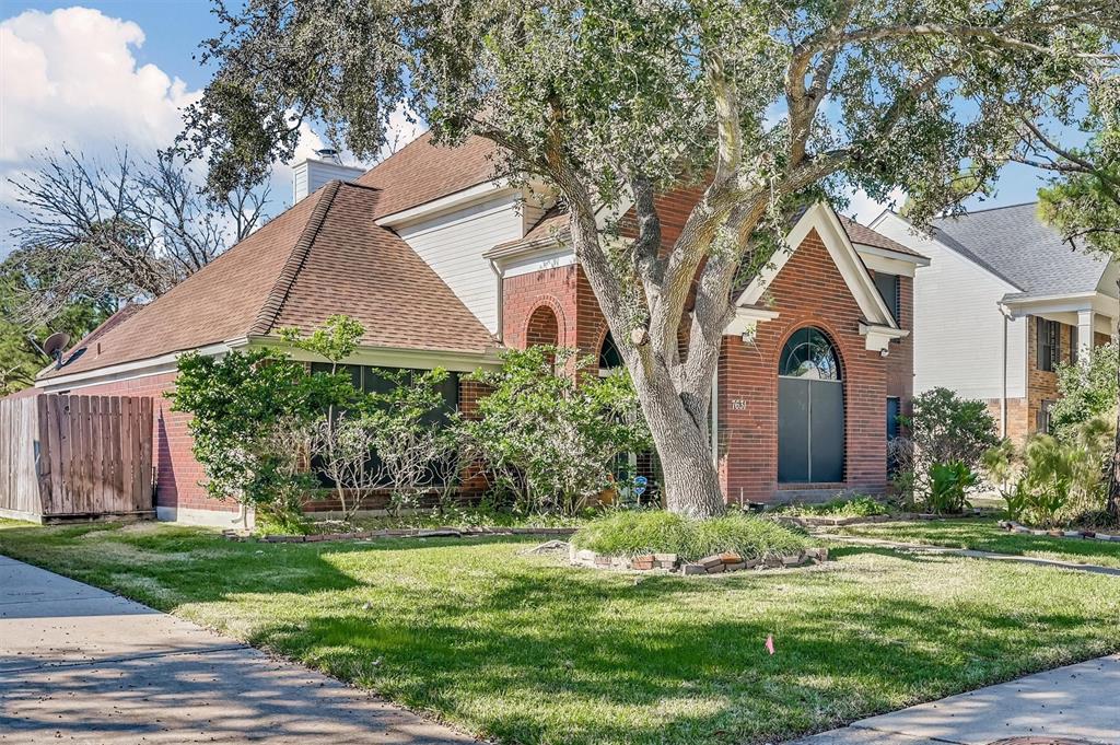 A manicured lawn frames the entrance. Architectural details, including arched windows and a big front yard.