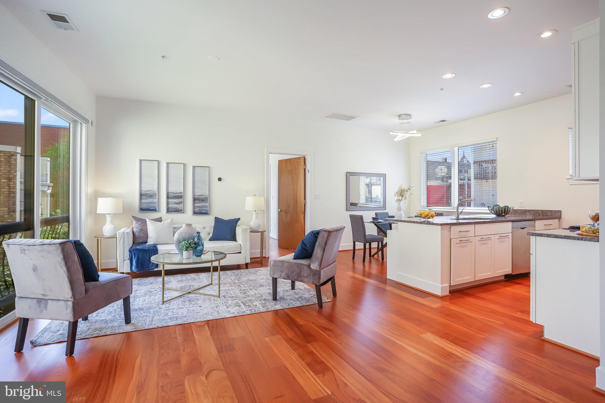 a living room with furniture and a wooden floor