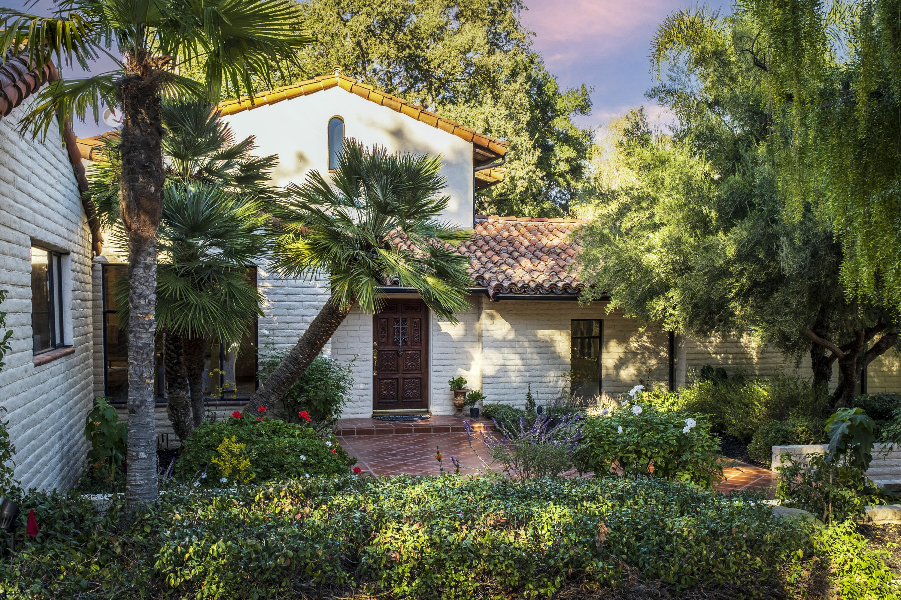 a front view of a house with a tree