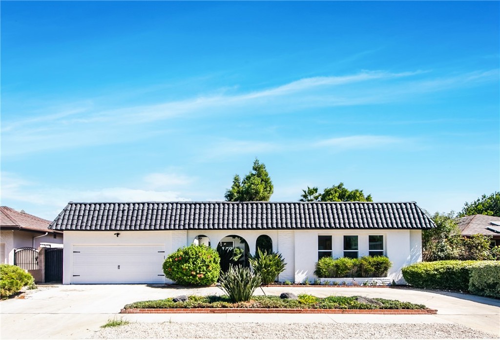 a view of a brick house and flower plants