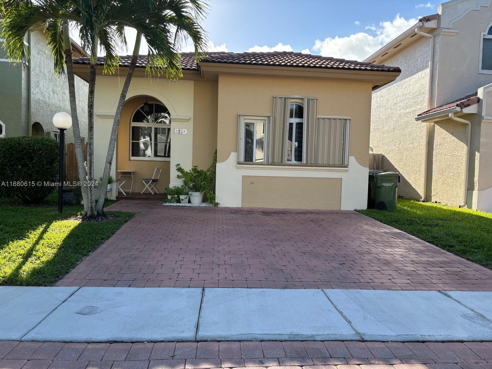 a view of a grey house with a yard