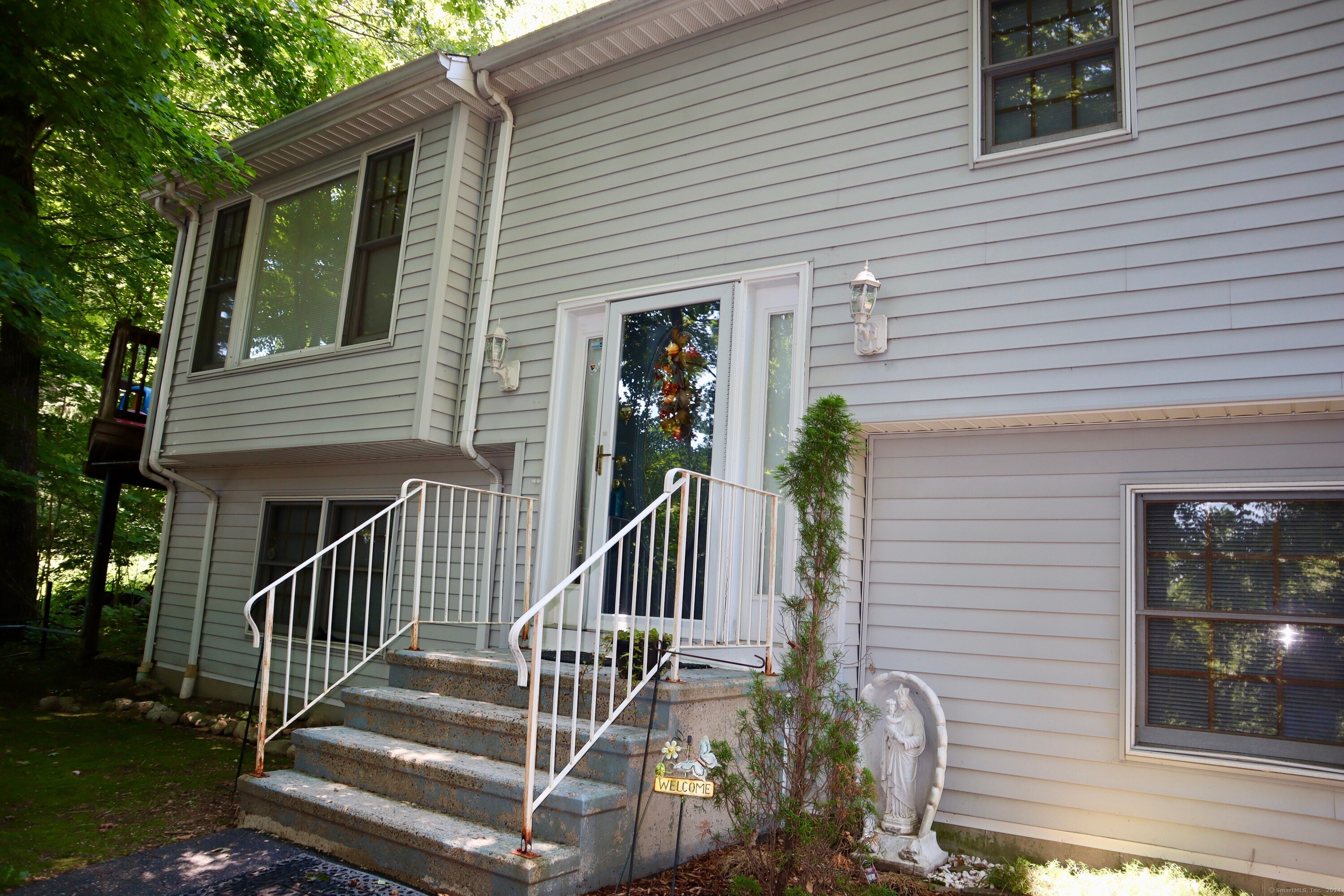 a view of house with deck and furniture