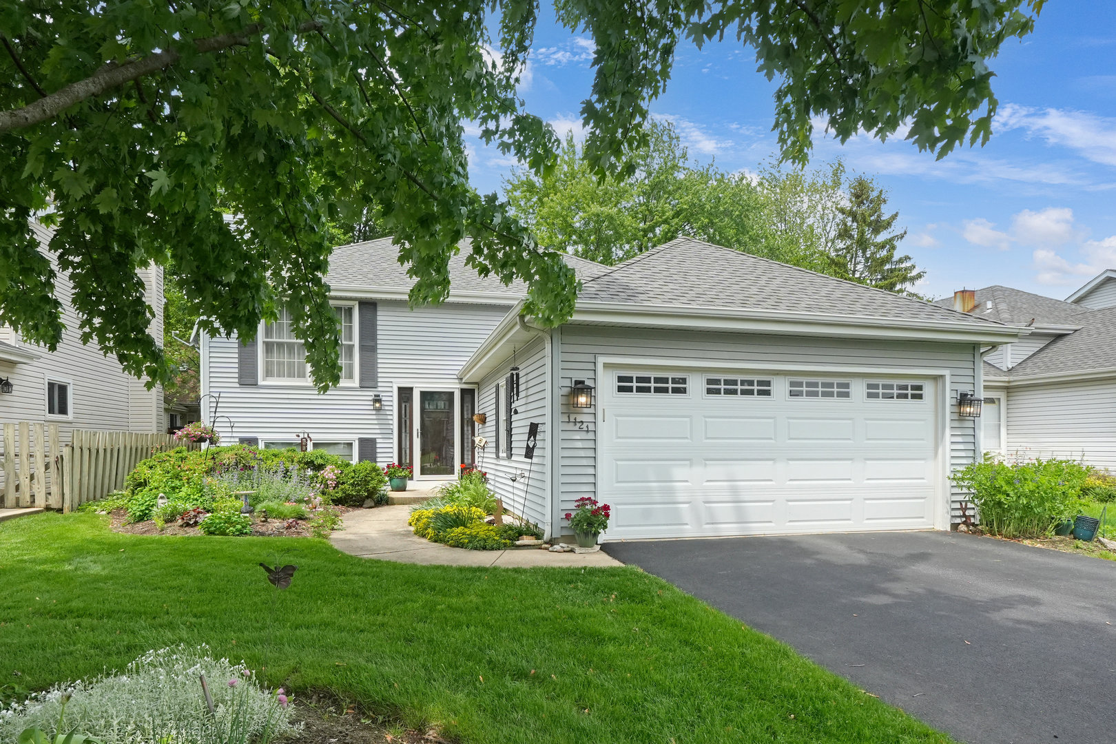 a front view of a house with a garden and plants