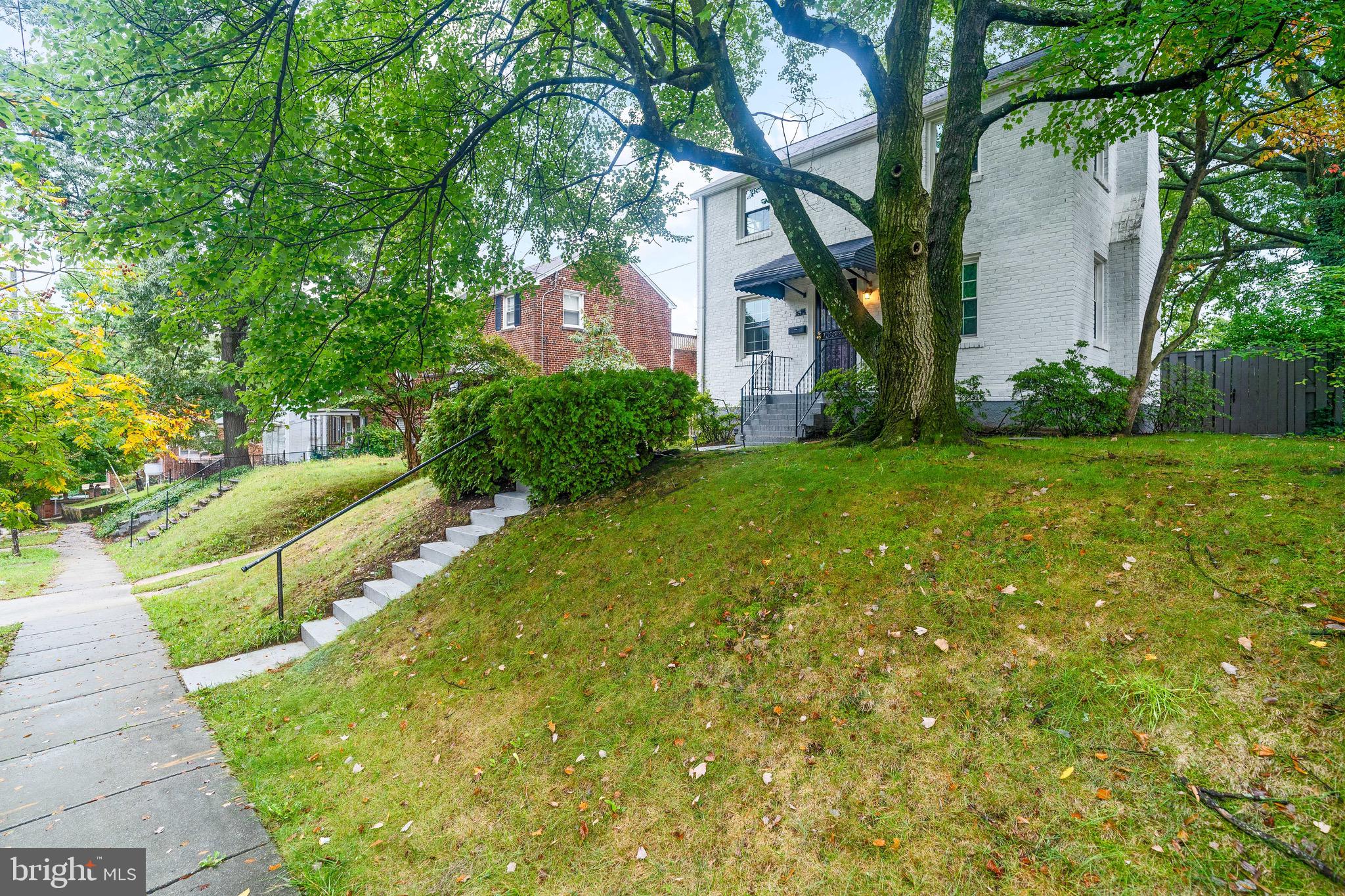 a view of a house with a yard and tree s