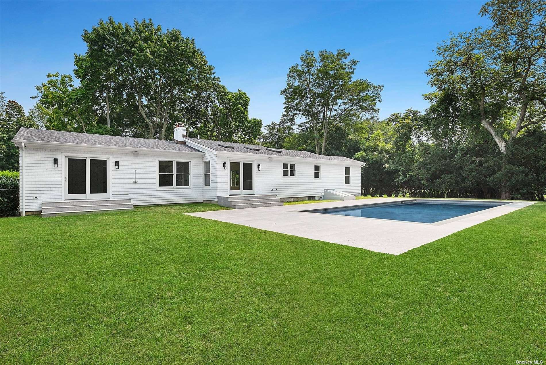 a view of house with backyard and swimming pool