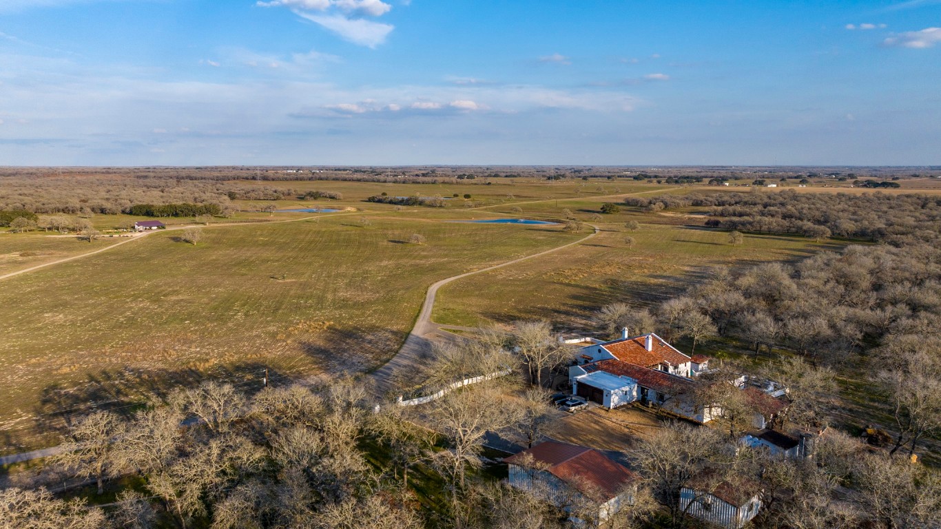 an aerial view of ocean and residential houses with outdoor space