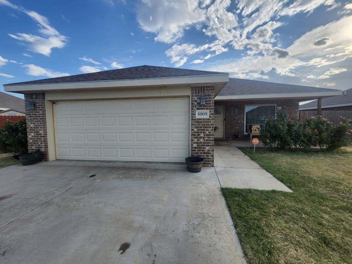 a view of a house with a yard and garage