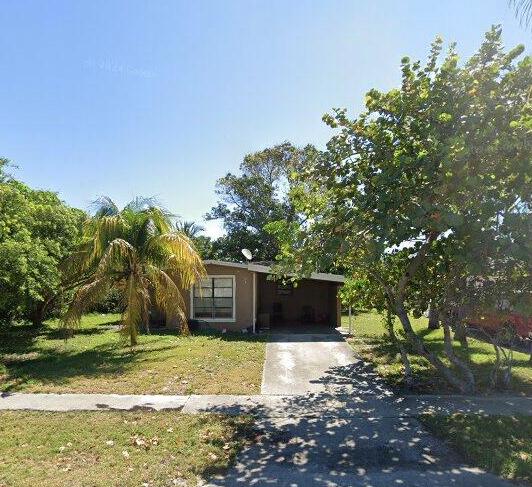 a view of a house with backyard and trees