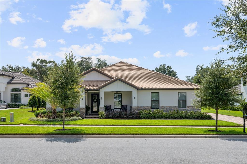 a front view of a house with a yard and trees