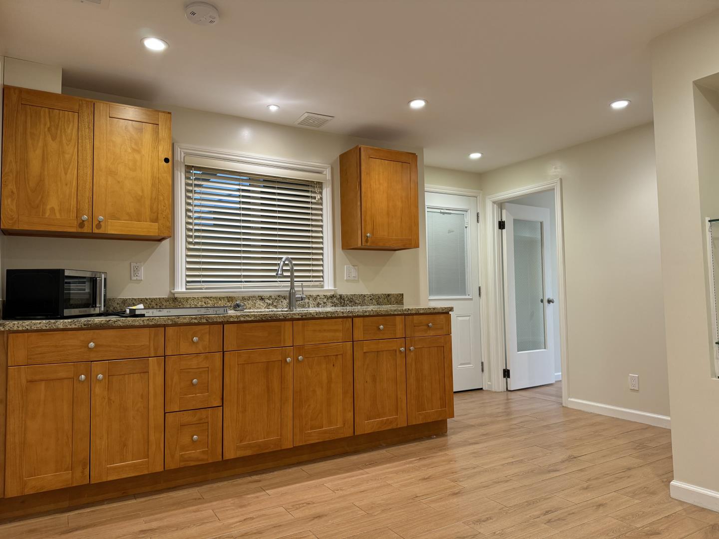 a large kitchen with granite countertop a sink and a stove top oven