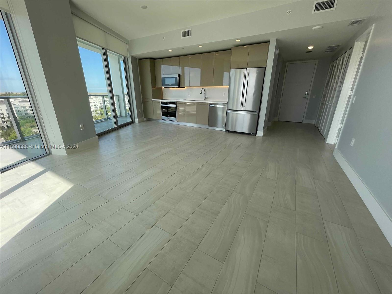 a view of a kitchen with a sink and a refrigerator