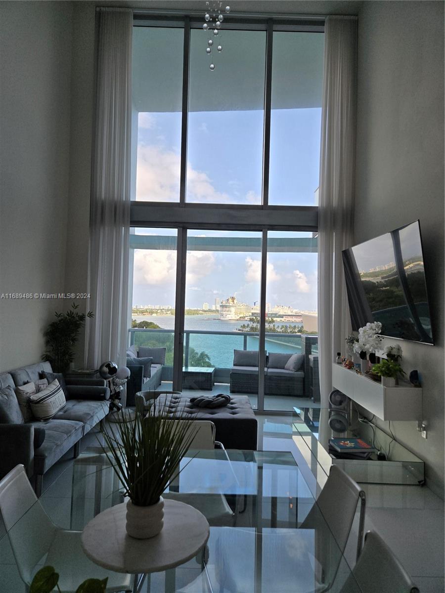 a living room with furniture large window and flat screen tv