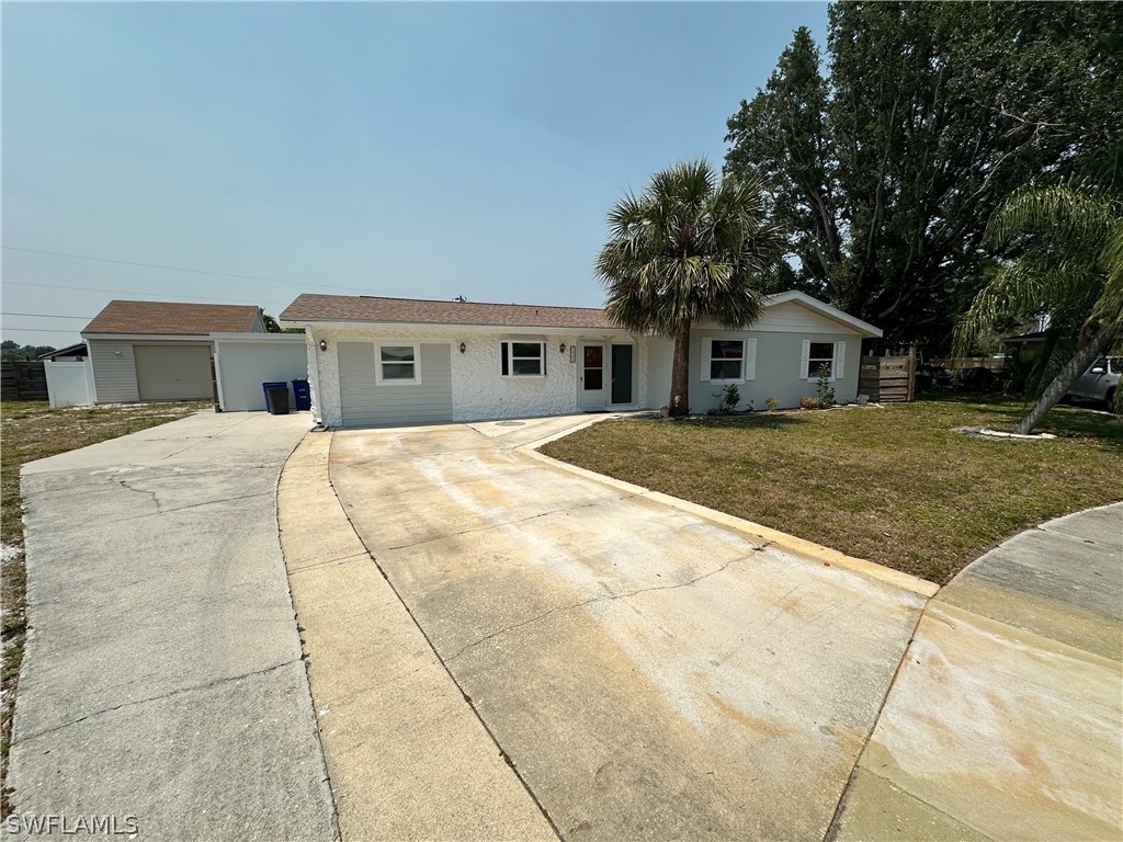 a view of a house with a yard and large tree