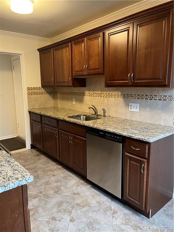 a kitchen with granite countertop stainless steel appliances a stove sink and cabinets