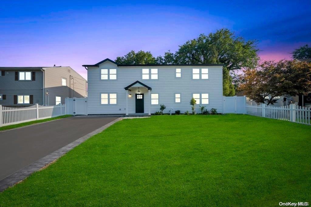 a front view of a house with a garden and yard