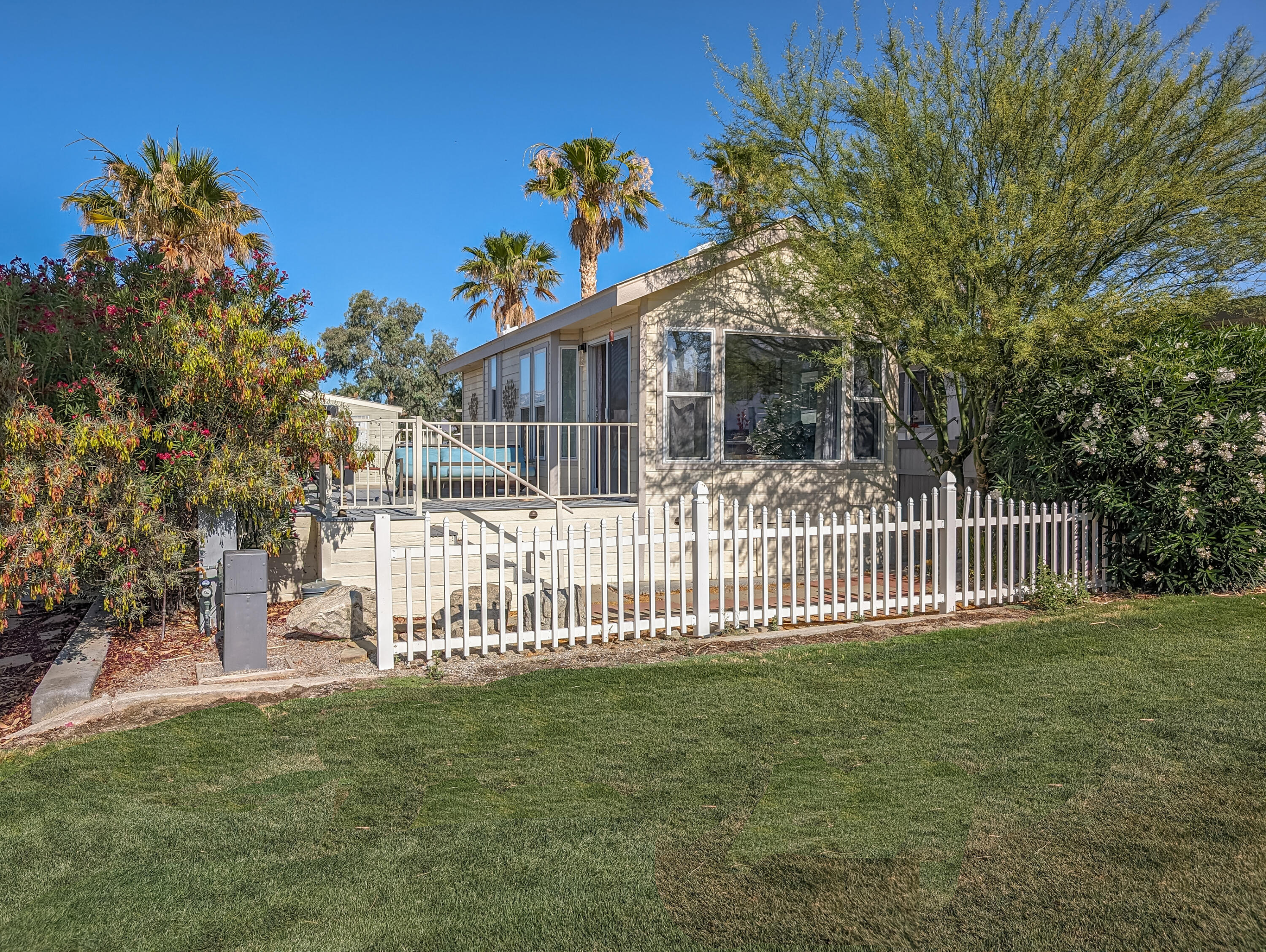 a view of a house with a small yard and wooden fence