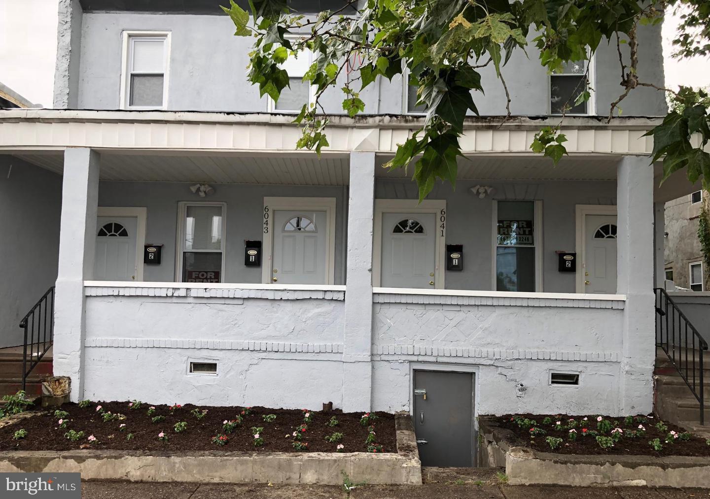 front view of house with a white building