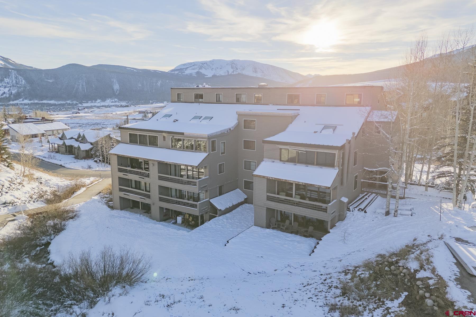 a front view of a house with a yard covered with snow in the background