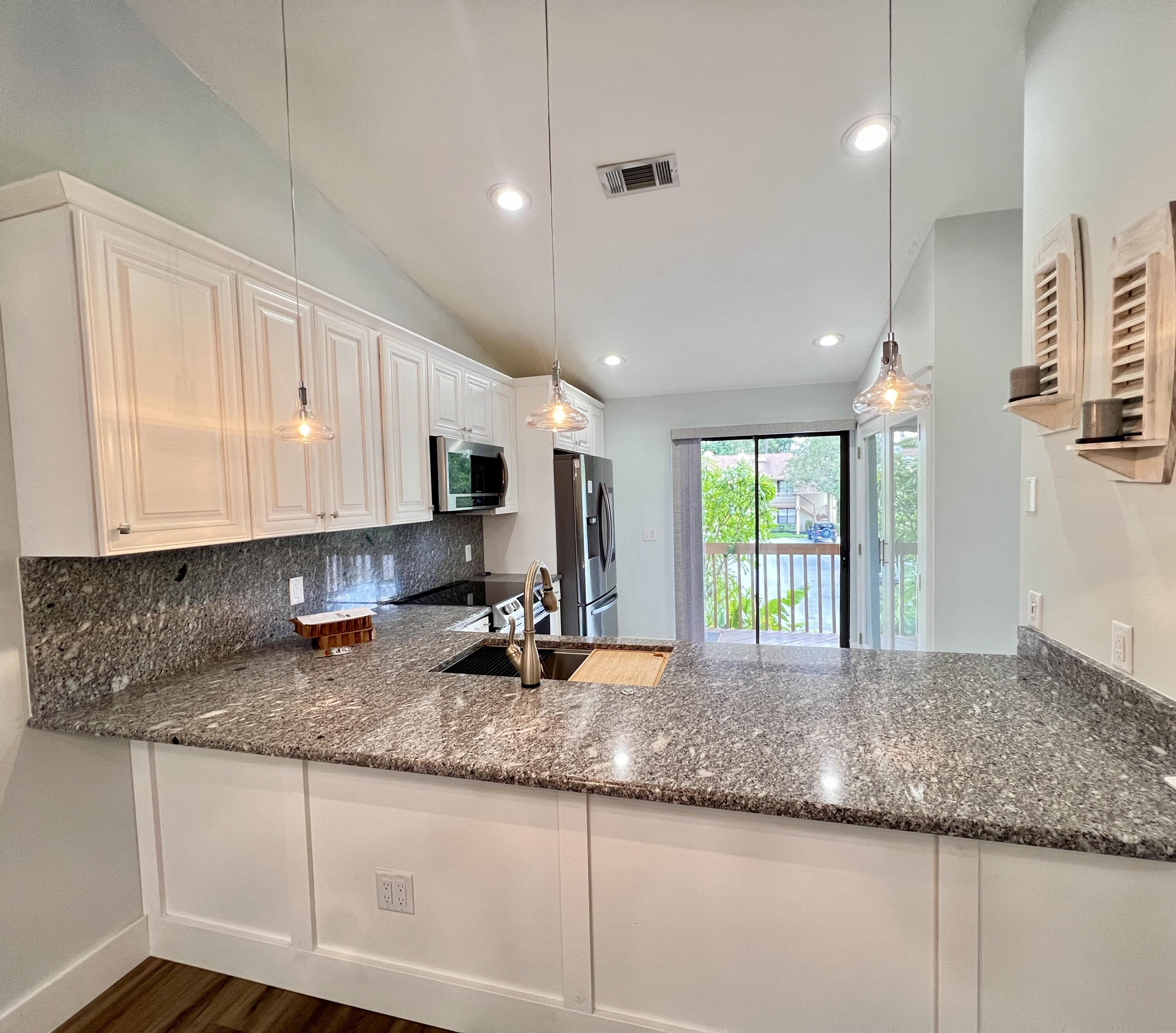 a kitchen with granite countertop sink and cabinets