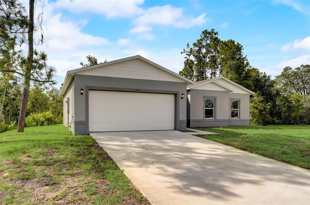 a front view of a house with a yard and garage