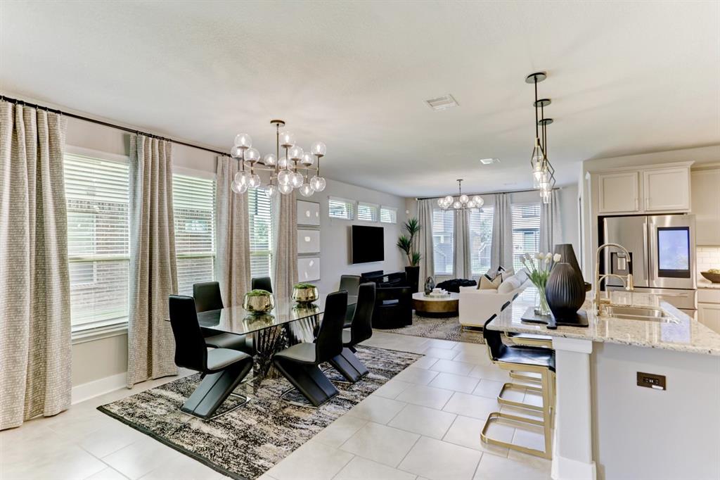 a living room with furniture a dining table and a floor to ceiling window