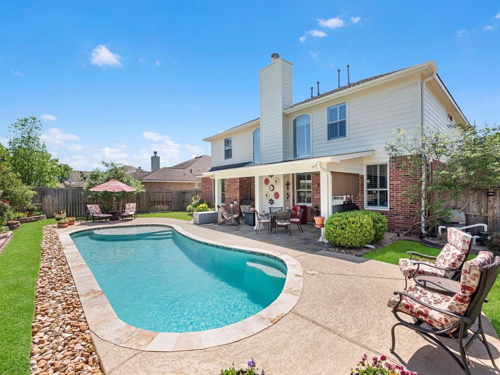 This is a two-story home featuring a private swimming pool with a surrounding concrete deck and landscaped garden, ideal for outdoor entertaining and relaxation.