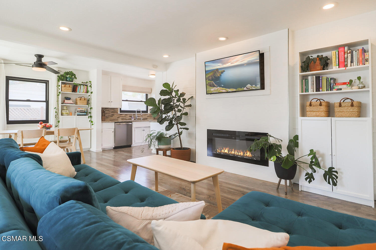 a living room with furniture a flat screen tv and a fireplace