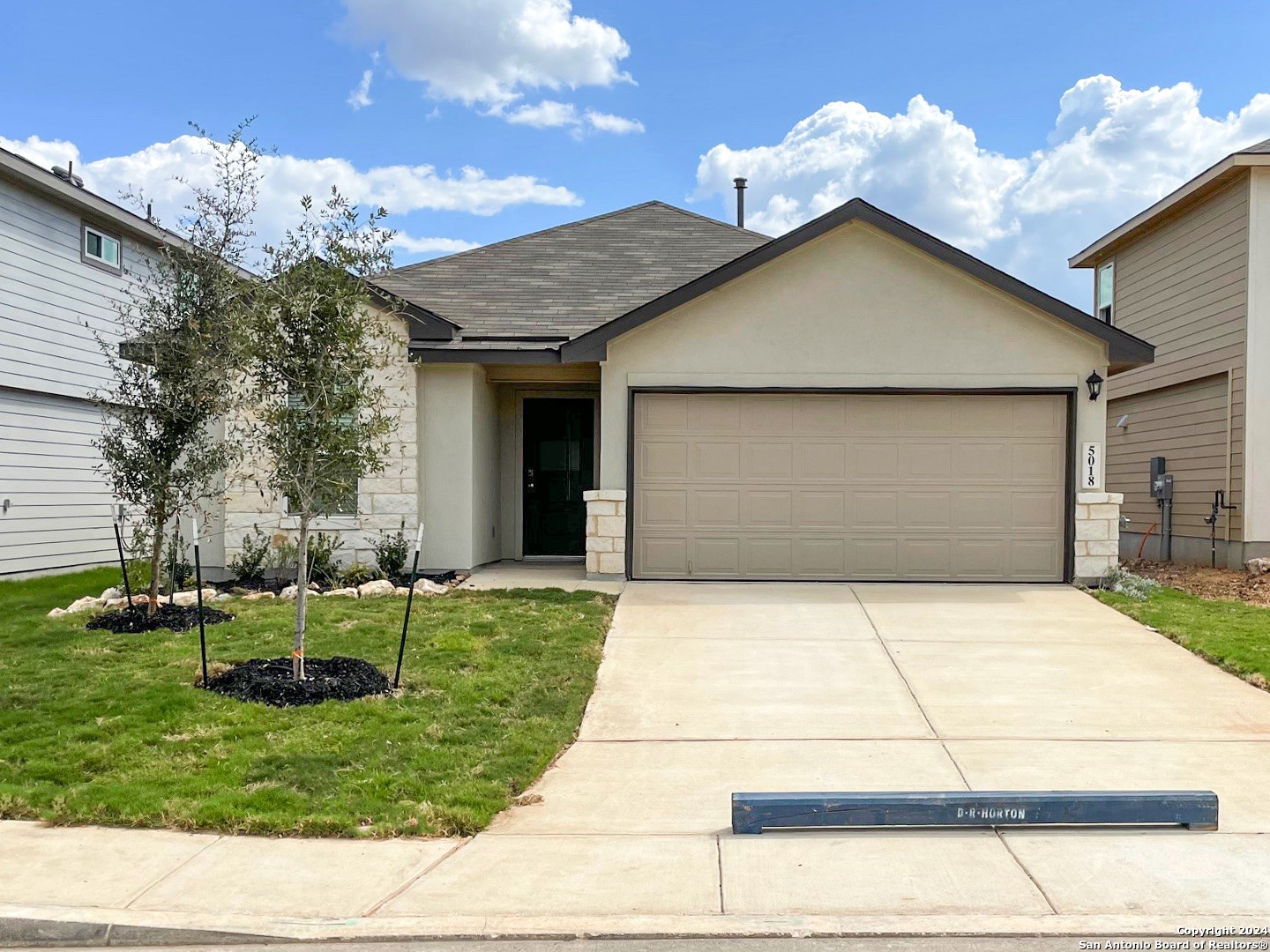 a front view of a house with a yard and garage