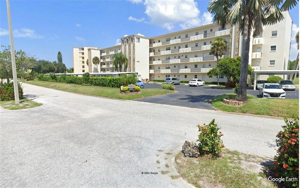 a view of a tall white building and palm trees