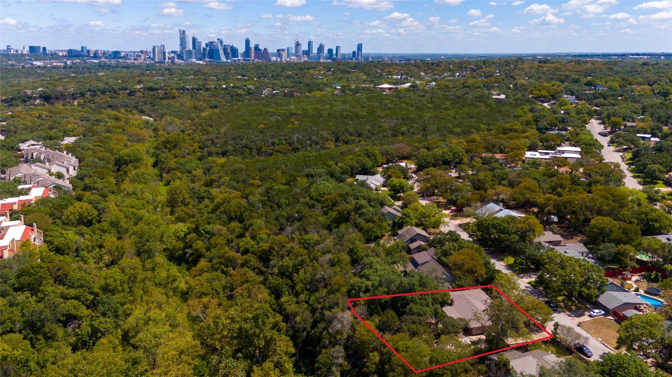 an aerial view of residential houses with outdoor space and trees