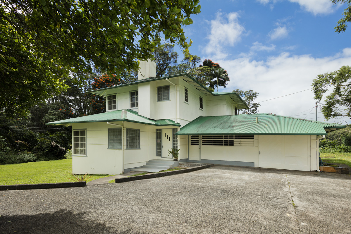 a front view of a house with a garden and garage