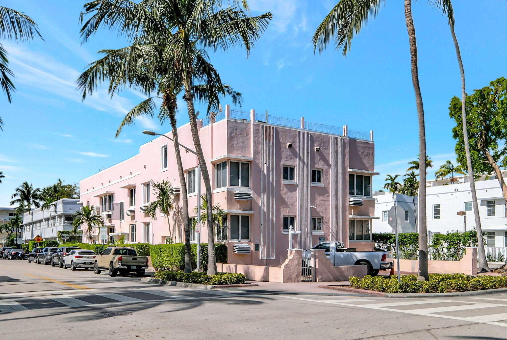 a view of a street with a building and palm trees