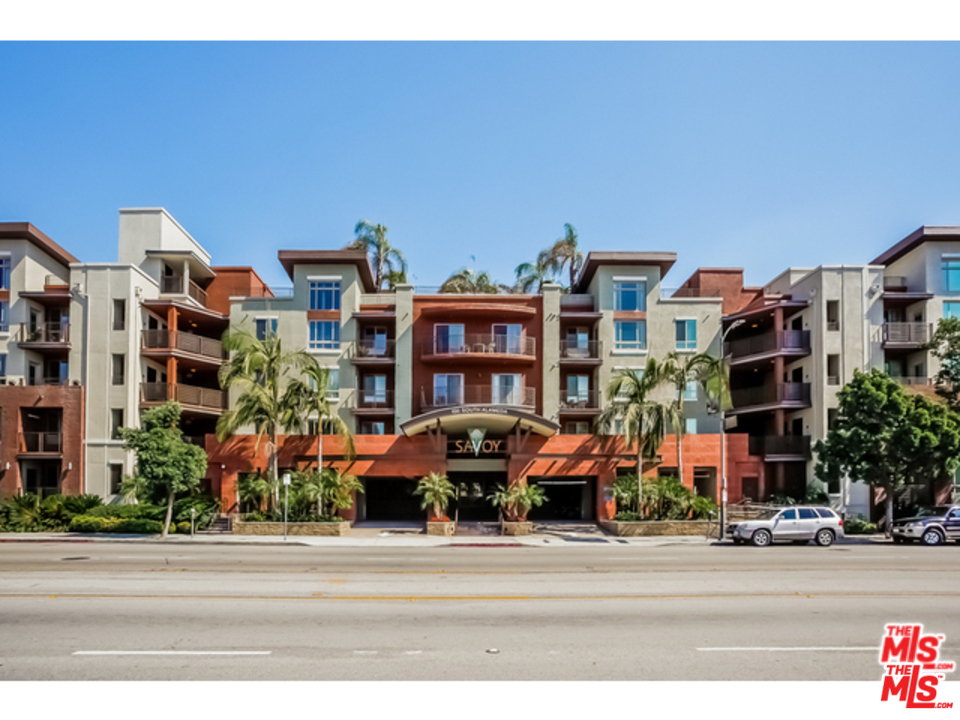 a front view of multi story residential apartment building with yard