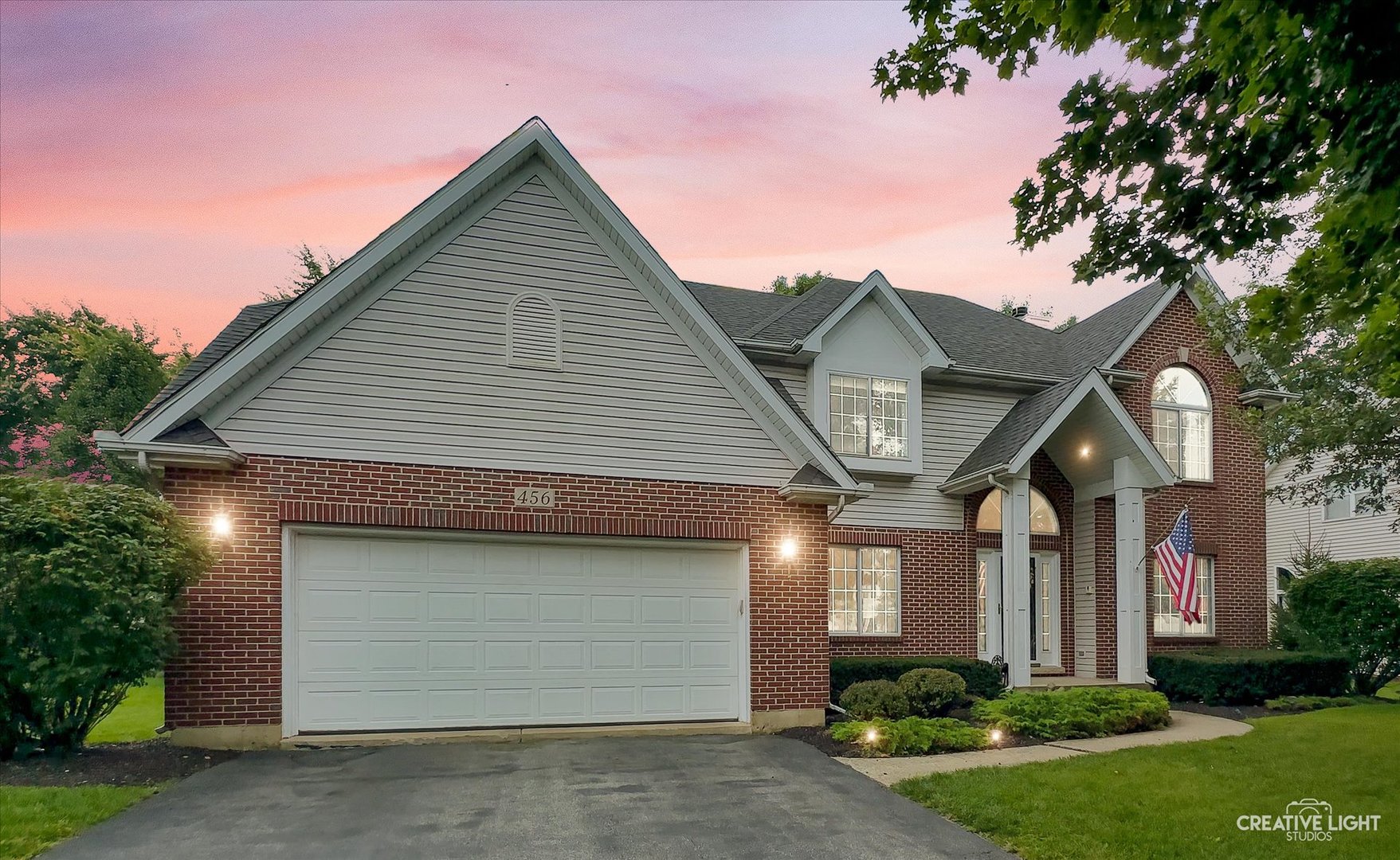 a front view of a house with a yard and garage