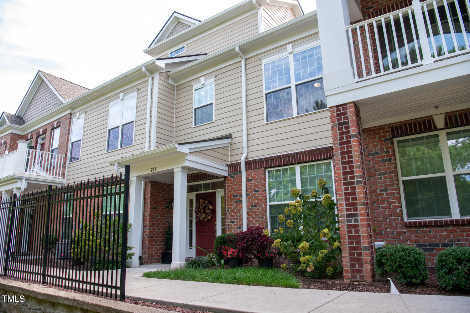 a view of a brick house with plants and large windows