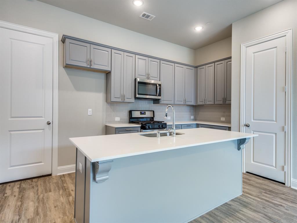 a kitchen with kitchen island a sink and wooden cabinets