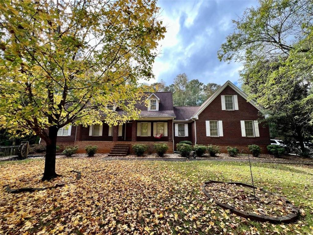 a front view of house with yard and trees around