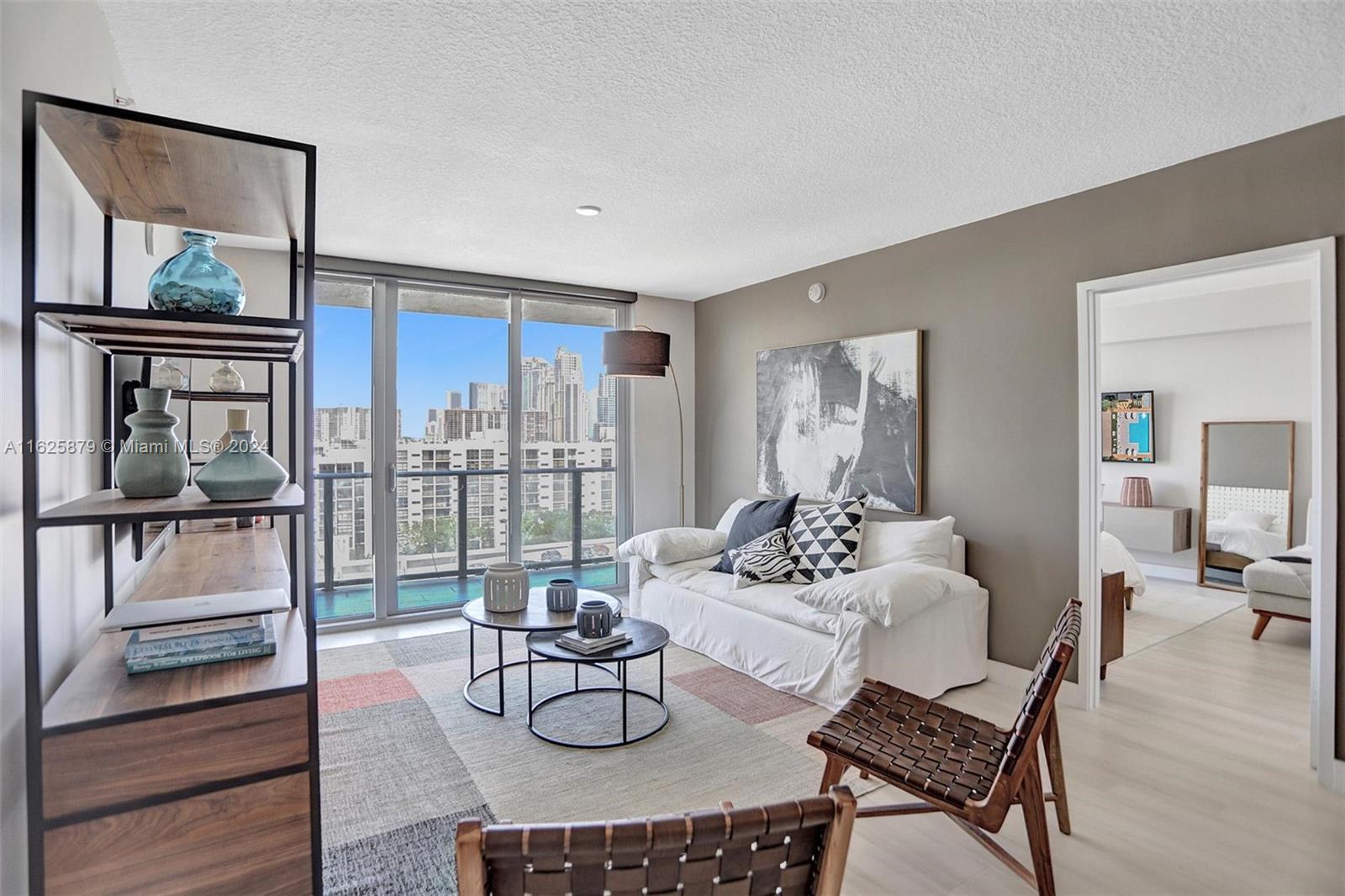 a living room with furniture and a floor to ceiling window