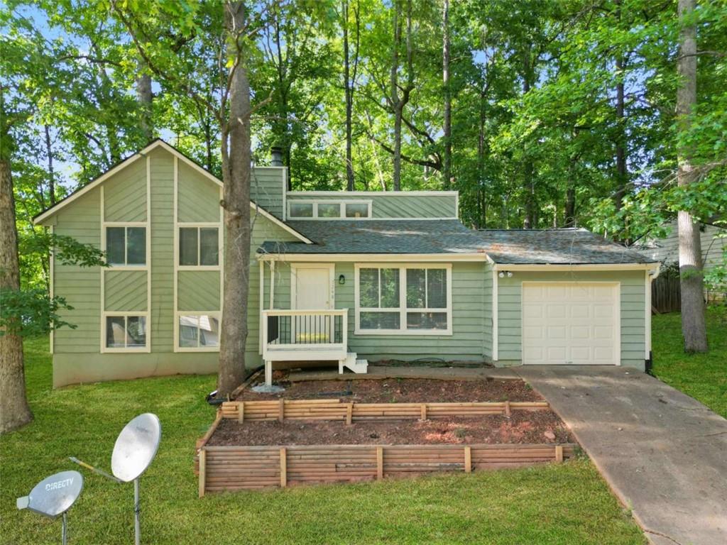 a front view of a house with a yard and trees