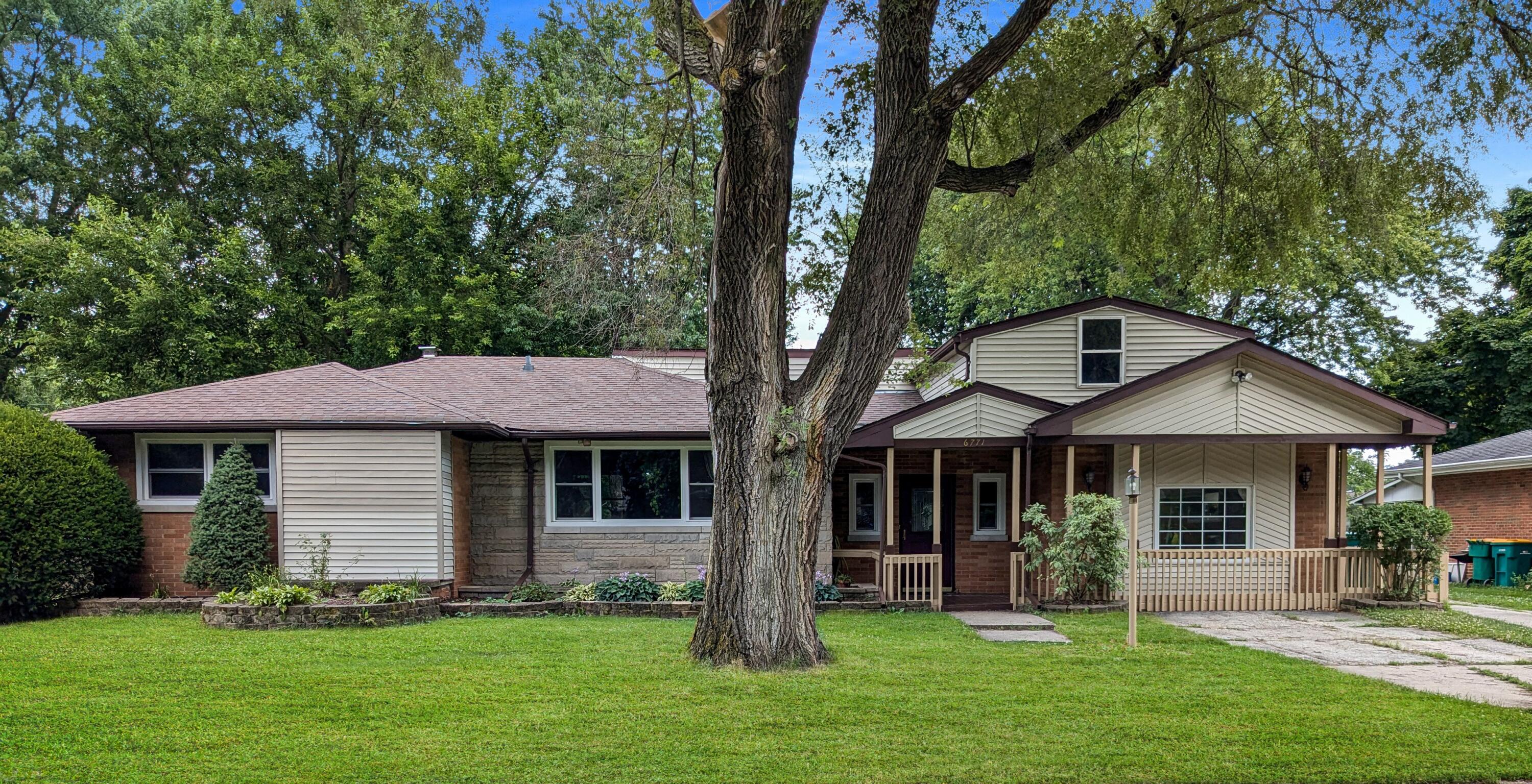 a front view of a house with a garden and yard