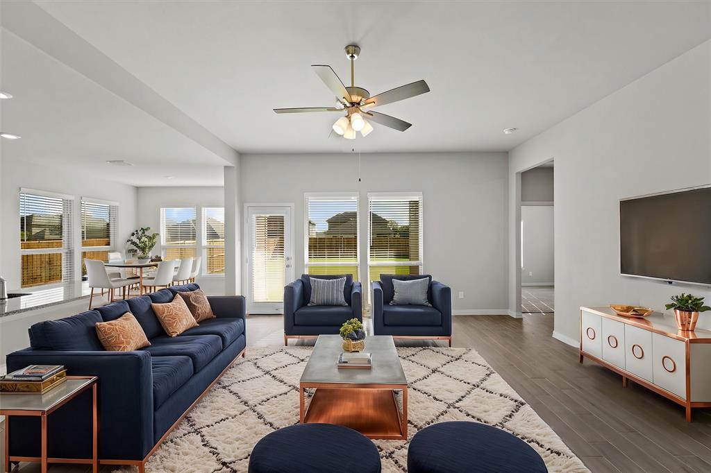 a living room with furniture a flat screen tv and a floor to ceiling window