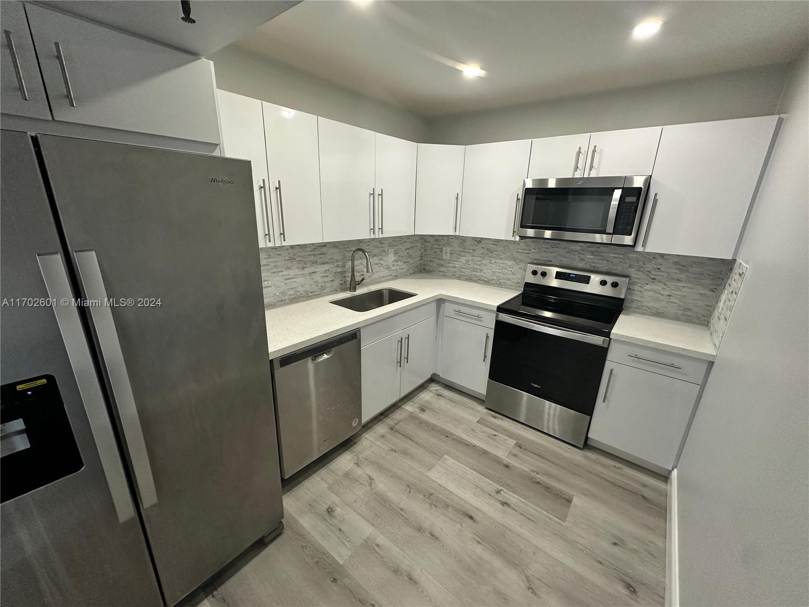 a kitchen with stainless steel appliances a refrigerator stove microwave and sink